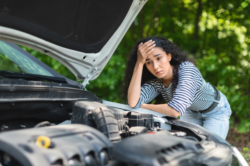 Driver looking at an open hood, representing the engine problems lemon law attorneys review in Engine Failure Claims.