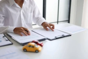 Attorney reviewing lemon law case documents with toy cars on desk